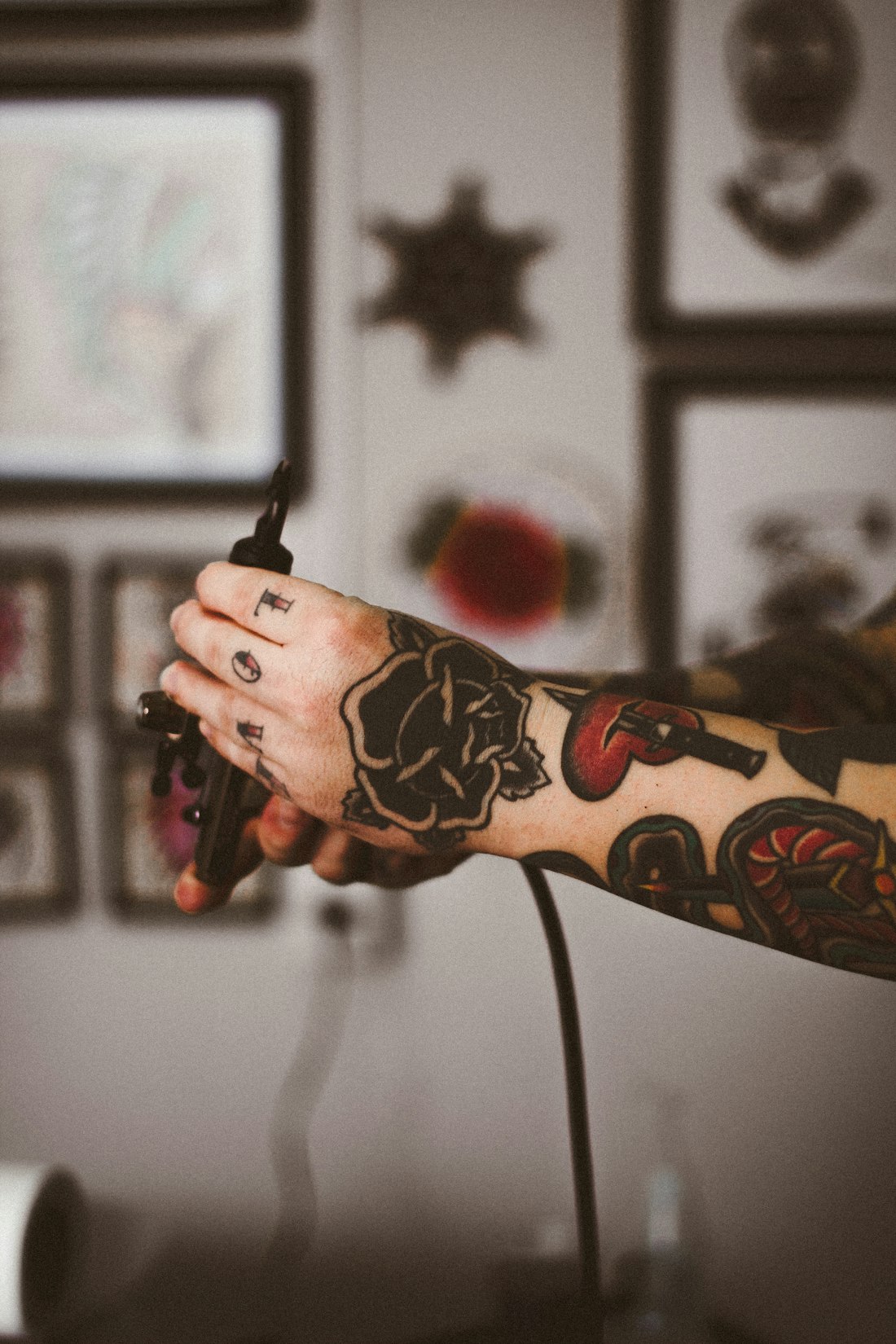 Tattoo artist with a traditional rose and dagger sleeve at work