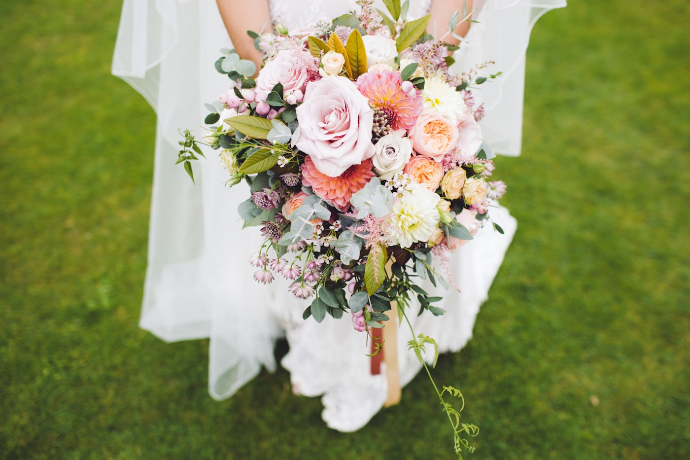 Bride holding a soft blush and peach bouquet