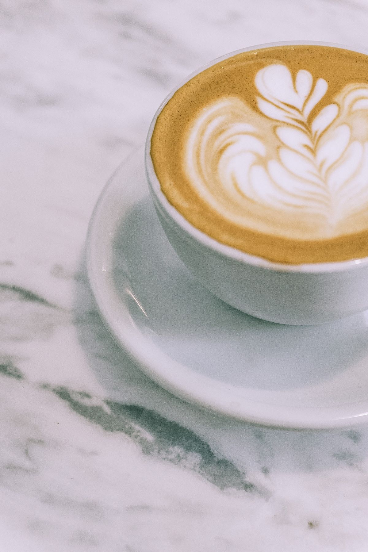 Latte with heart-shaped latte art on a marble table